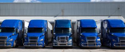 Five semi trucks parked in a row